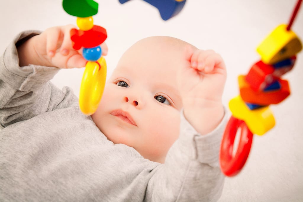 functional play as one of types of children's play: children's play with baby rattle children's play with baby rattle